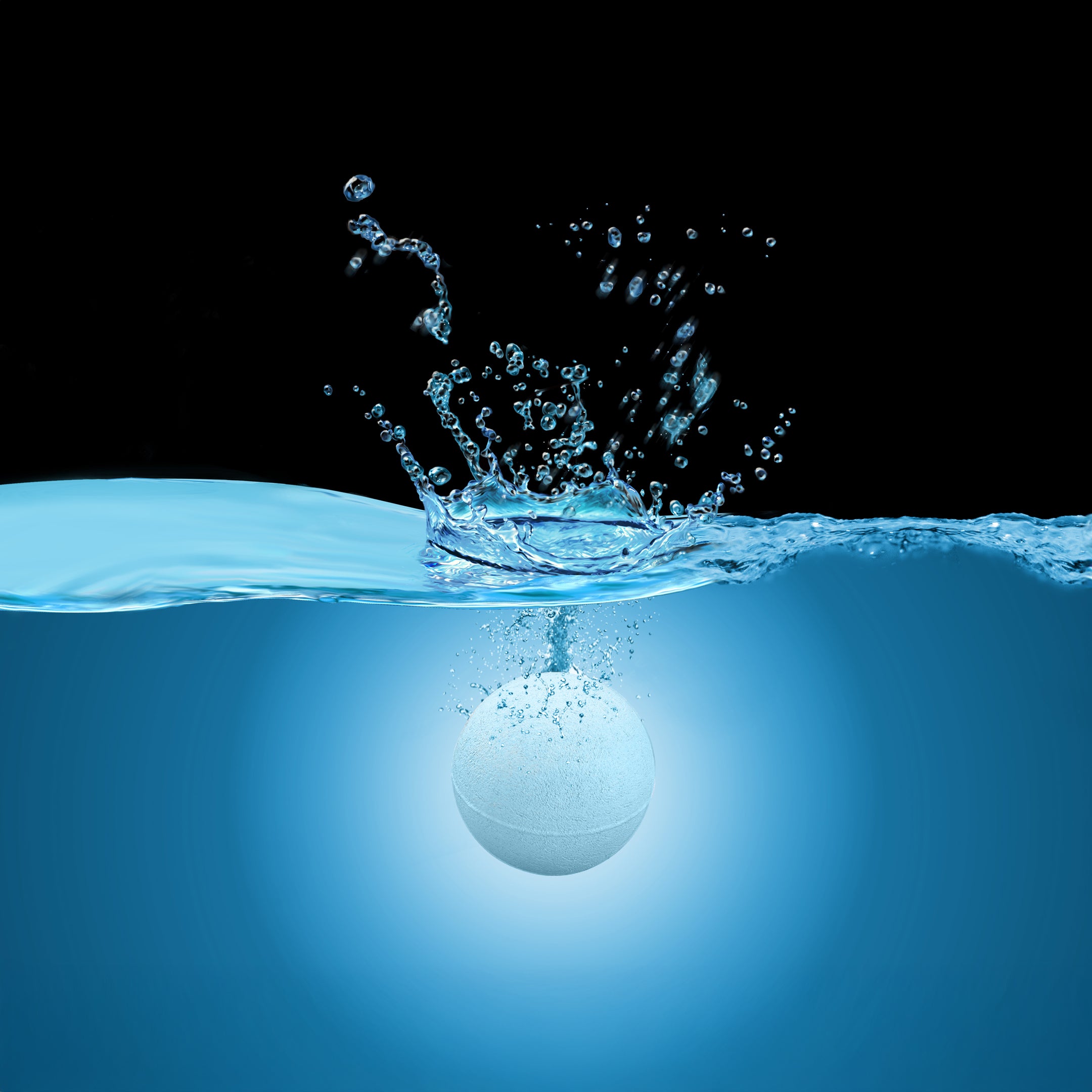 White Muscle Rehab bath bomb splashing into blue water, creating droplets and ripples against a black background, symbolizing freshness, relaxation, and the start of a soothing soak.